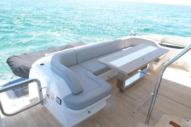 Slide: The Image of Luxurious 2022 Pearl 62 yacht deck with seating and table, overlooking the ocean. - 10