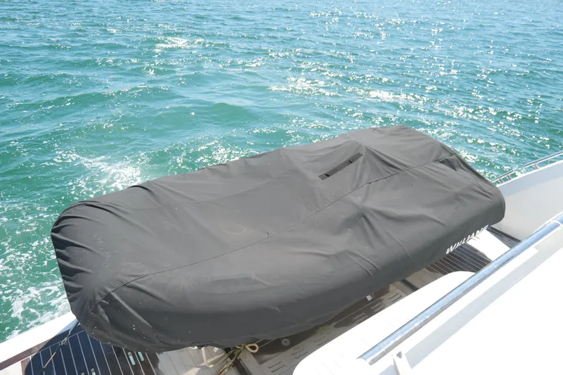 Slide: The Image of Covered Pearl 62 boat on water, 2022 model, with black protective cover. - 58