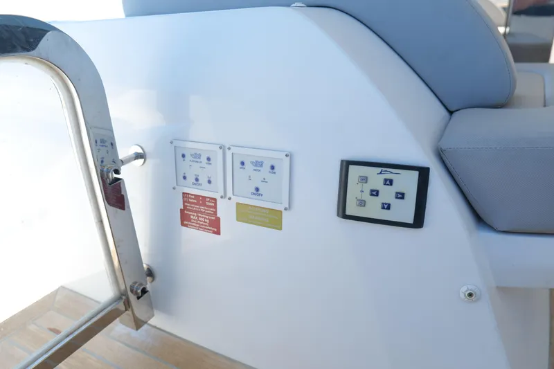 Slide: The Image of Control panel on a 2022 Pearl 62 yacht, featuring buttons and warning labels. - 57