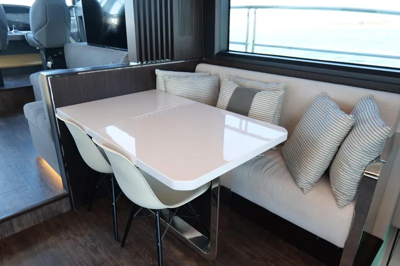Slide: The Image of Luxurious dining area on 2022 Pearl 62 yacht with modern table and striped cushions. - 16