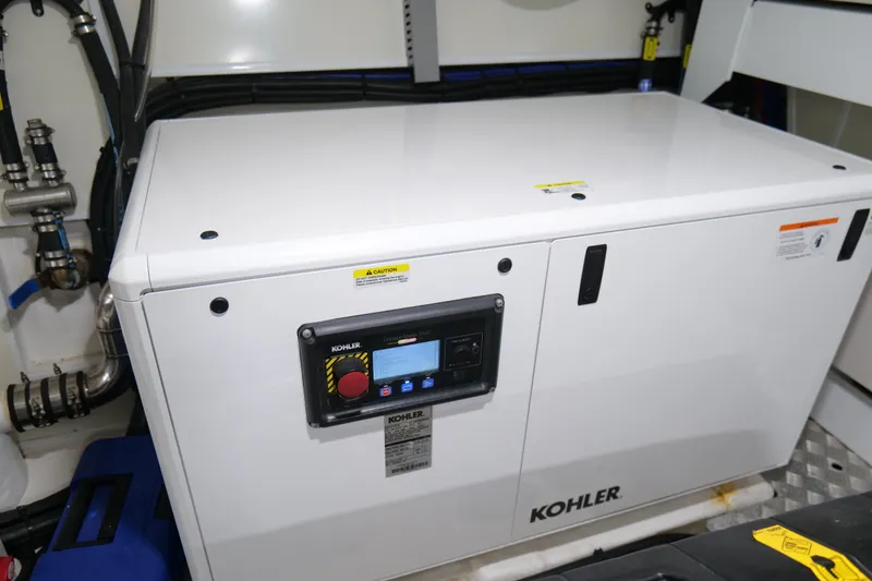 Slide: The Image of Kohler generator in 2022 Pearl 62 yacht engine room, featuring control panel and piping. - 69