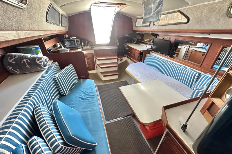 Slide: The Image of Interior of a 1976 Islander 36 sailboat with striped seating and nautical decor. - 13