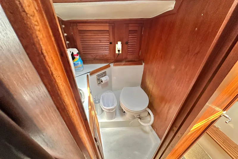 Slide: The Image of 1976 Islander 36 yacht bathroom with wooden cabinetry and compact toilet. - 18