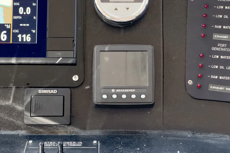 Slide: The Image of A control panel with Simrad display and Seakeeper control, surrounded by various switches and gauges. - 32
