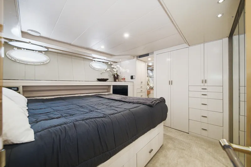 Slide: The Image of Luxurious cabin with a large bed, white cabinets, and porthole windows aboard a 1990 Westport Crescent. - 47