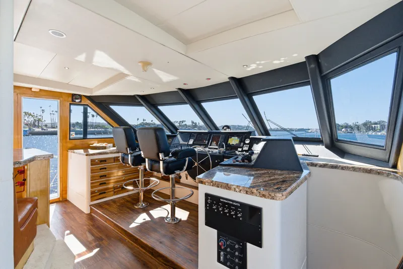 Slide: The Image of The helm of a 1990 Westport Crescent with modern navigation instruments and panoramic windows. - 25