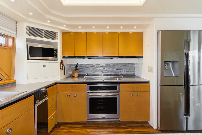 Slide: The Image of The kitchen on the 1990 Westport Crescent features a modern design with wooden cabinets and stainless steel appliances. - 21