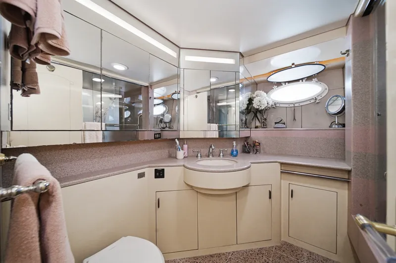 Slide: The Image of An elegant bathroom with mirrors, sink, and towels. Round windows offer a view outside. - 44