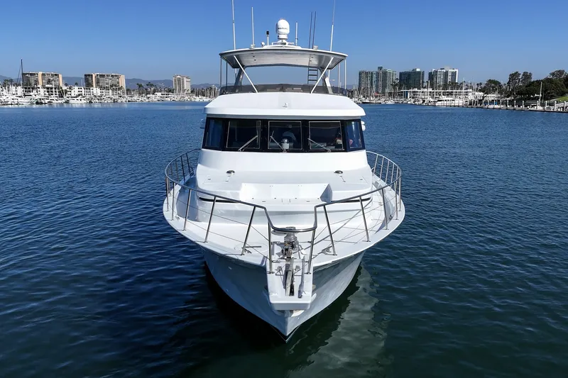 Slide: The Image of A 1990 Westport Crescent yacht cruising on calm waters with a cityscape in the background. - 5
