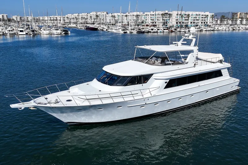 The Image of A luxurious white yacht anchored in a harbor, surrounded by other boats and buildings. - 0