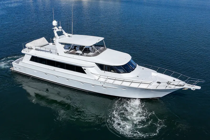 Slide: The Image of A sleek white yacht cruises on calm water. It features a spacious deck and modern amenities. - 4