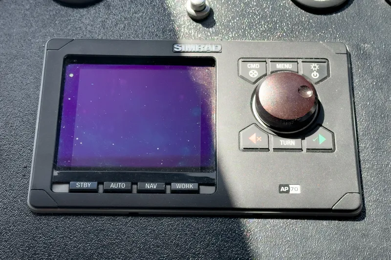 Slide: The Image of A Simrad control device on a boat, surrounded by buttons and a rotary knob. - 33