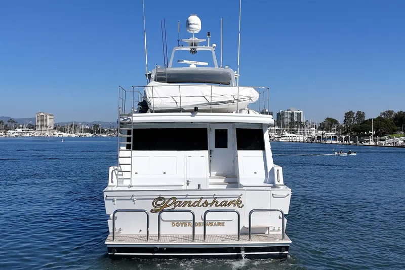 Slide: The Image of A luxury yacht named "Landshark" is on the water, surrounded by a marina. - 12