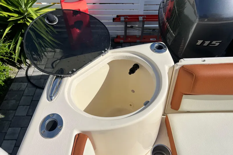Slide: The Image of 2014 Scout 245 XSF boat with open storage compartment and visible engine. - 48