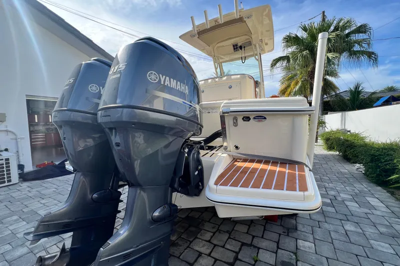 Slide: The Image of 2014 Scout 245 XSF boat with twin Yamaha 115 engines on a sunny driveway. - 30