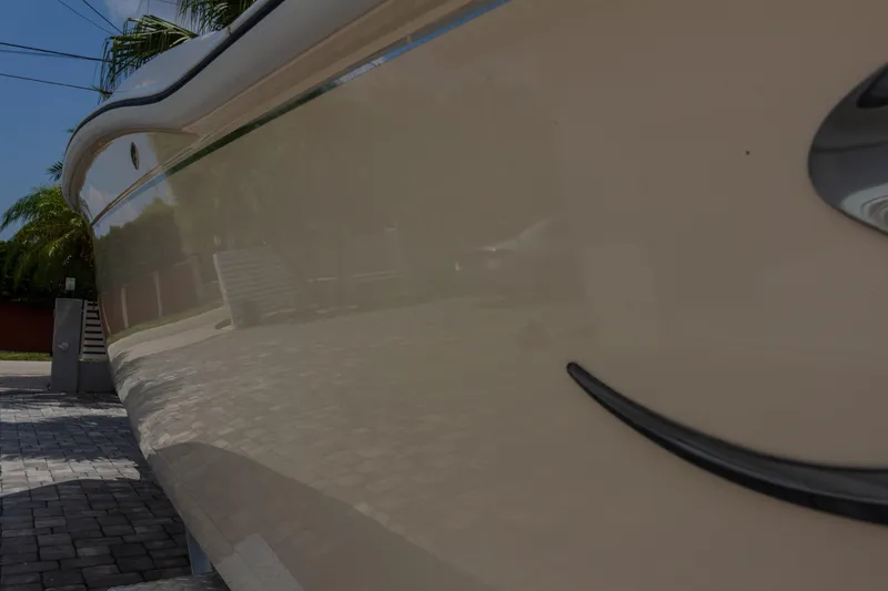 Slide: The Image of Side view of a 2014 Scout 245 XSF boat, parked on a paved driveway. - 18