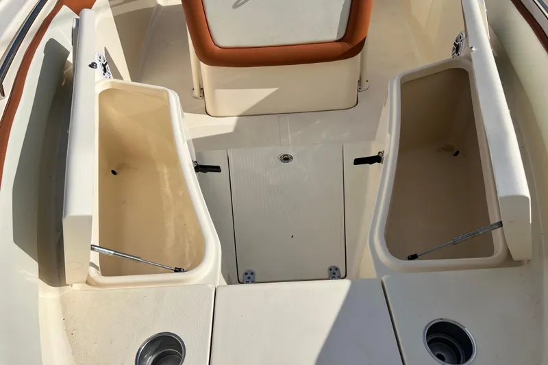 Slide: The Image of 2014 Scout 245 XSF boat interior with open storage compartments and seating. - 82