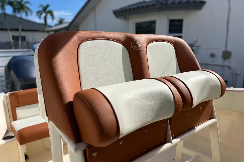 Slide: The Image of 2014 Scout 245 XSF boat seat with brown and white upholstery, outdoor setting. - 41