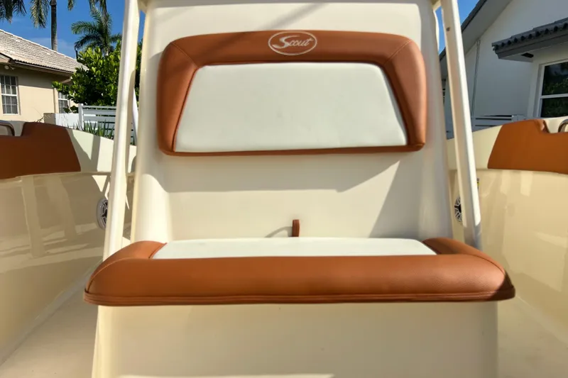 Slide: The Image of 2014 Scout 245 XSF boat seat with tan and white upholstery, outdoor setting. - 85