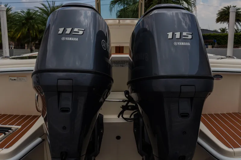 Slide: The Image of Twin Yamaha 115 engines on a 2014 Scout 245 XSF boat, docked with palm trees. - 13