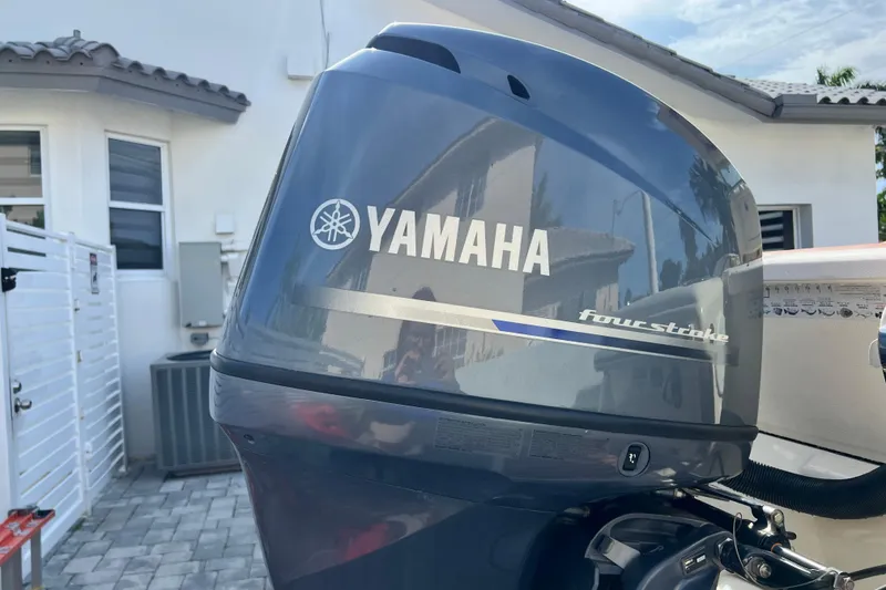 Slide: The Image of Yamaha four-stroke engine on a 2014 Scout 245 XSF boat, parked near a house. - 31