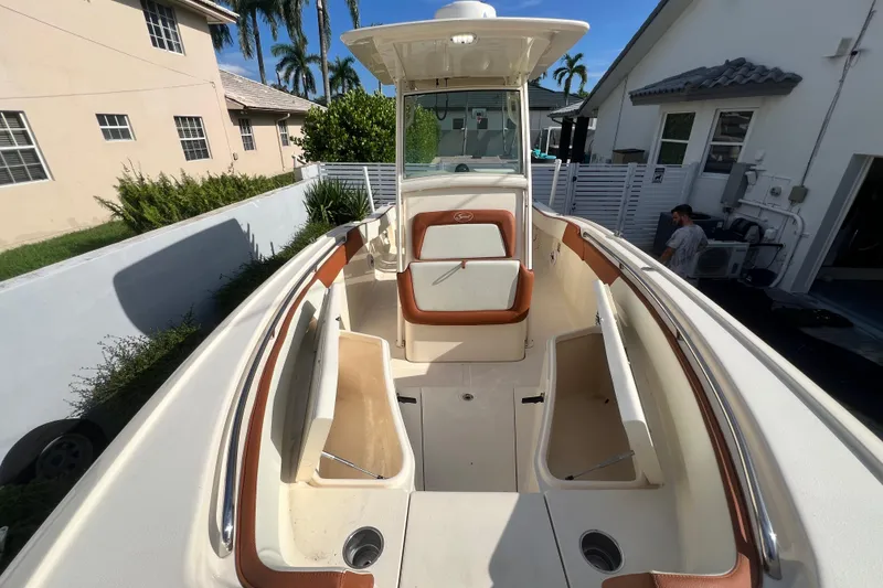 Slide: The Image of 2014 Scout 245 XSF boat with spacious seating and sleek design in residential setting. - 80
