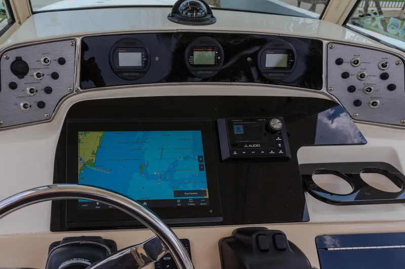 Slide: The Image of Dashboard of a 2014 Scout 245 XSF boat with navigation and audio controls. - 12