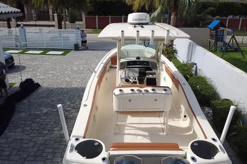Slide: The Image of 2014 Scout 245 XSF boat with Garmin equipment, parked on a paved driveway. - 6