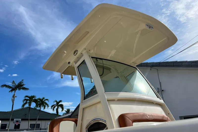 Slide: The Image of 2014 Scout 245 XSF boat with T-top against a clear blue sky. - 28