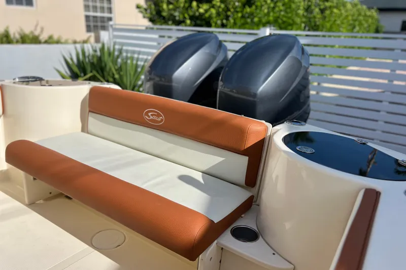 Slide: The Image of 2014 Scout 245 XSF boat interior with brown and white seating, dual engines visible. - 43