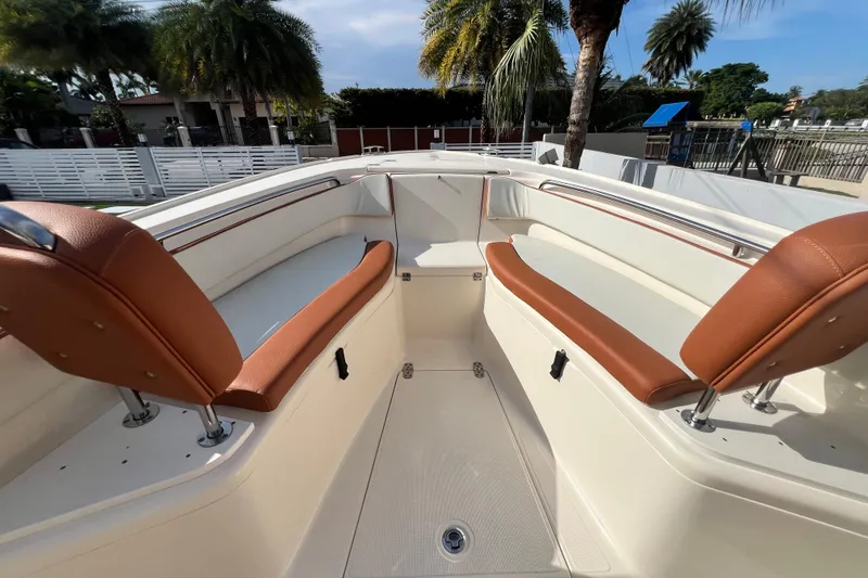 Slide: The Image of 2014 Scout 245 XSF boat interior with tan seating and palm trees in the background. - 69