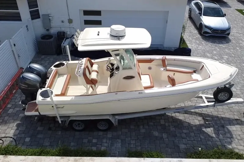 Slide: The Image of 2014 Scout 245 XSF boat on trailer, parked in driveway with dual Yamaha engines. - 7