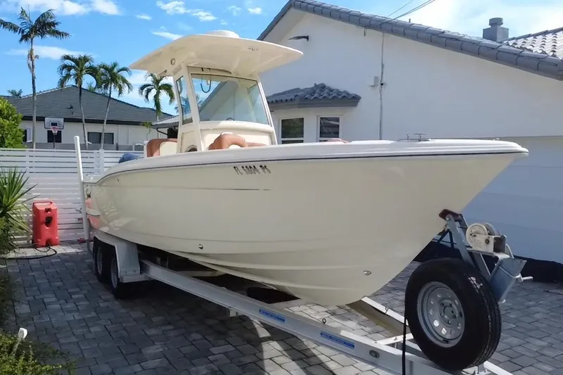 Slide: The Image of 2014 Scout 245 XSF boat on trailer in residential driveway, sunny day. - 21