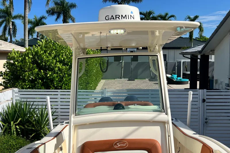 Slide: The Image of 2014 Scout 245 XSF boat with Garmin equipment, parked near tropical greenery and modern homes. - 77