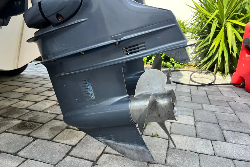 Slide: The Image of 2014 Scout 245 XSF boat motor propeller on paved surface, with greenery in background. - 38