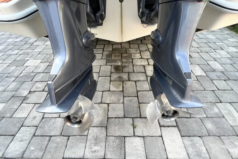 Slide: The Image of Twin outboard motors on a 2014 Scout 245 XSF boat, parked on a stone driveway. - 34