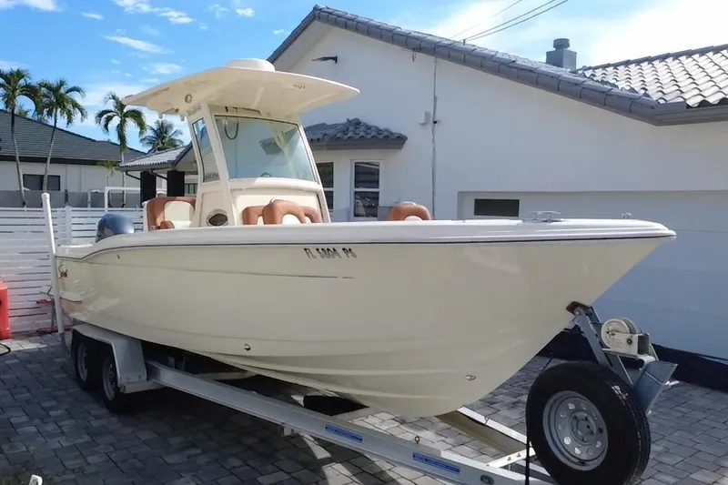 Slide: The Image of 2014 Scout 245 XSF boat on trailer, parked in driveway near house. - 22