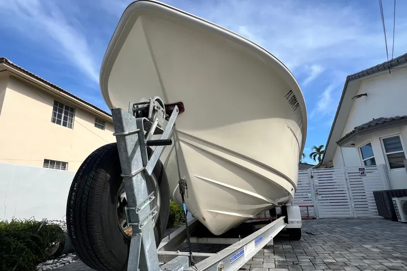 Slide: The Image of 2014 Scout 245 XSF boat on trailer, parked in residential driveway. - 25