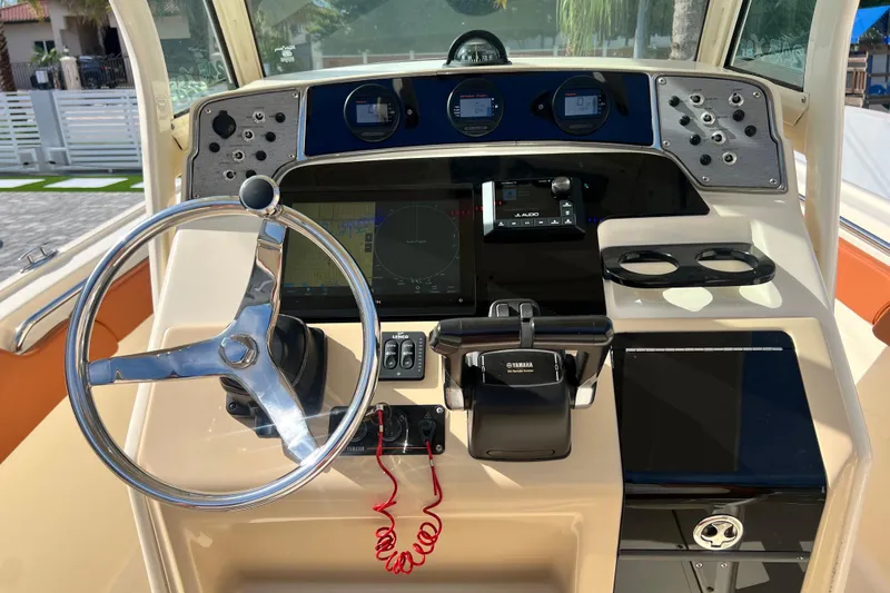 Slide: The Image of Steering console of a 2014 Scout 245 XSF boat with modern controls and gauges. - 53