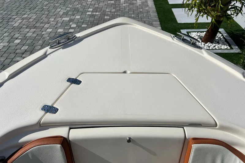 Slide: The Image of Bow of 2014 Scout 245 XSF boat with hatch and cleats, on paved surface. - 72