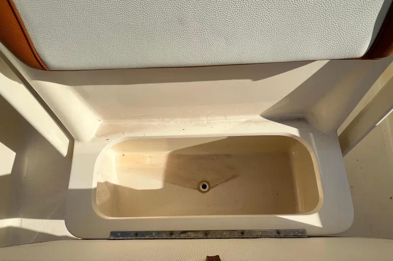 Slide: The Image of Storage compartment on a 2014 Scout 245 XSF boat, featuring a clean, white interior. - 84