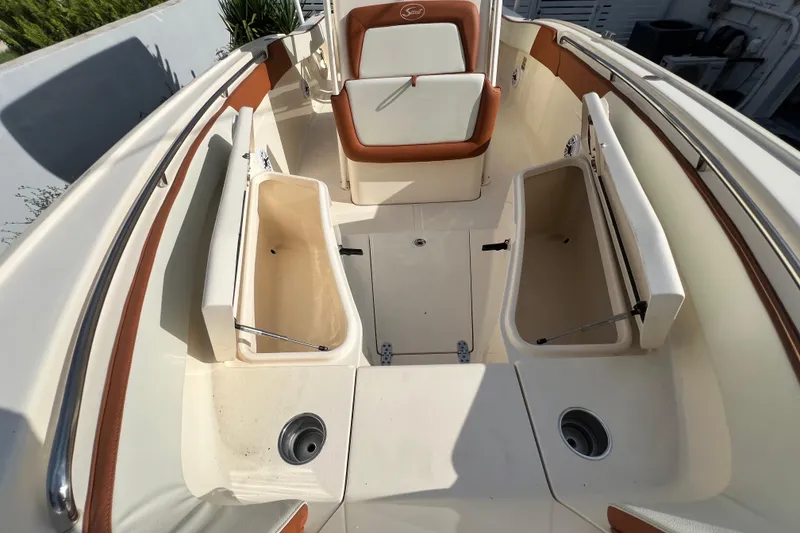 Slide: The Image of 2014 Scout 245 XSF boat interior with open storage compartments and seating. - 81