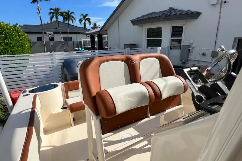Slide: The Image of 2014 Scout 245 XSF boat with dual seats and steering wheel, parked outdoors. - 63
