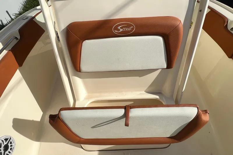 Slide: The Image of 2014 Scout 245 XSF boat interior with brown and white cushioned seating. - 83