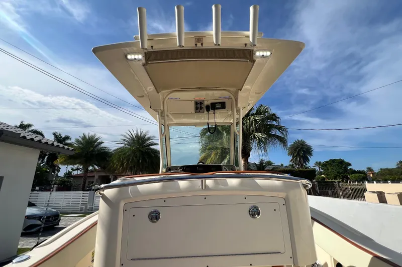 Slide: The Image of 2014 Scout 245 XSF boat with T-top, palm trees in background. - 49