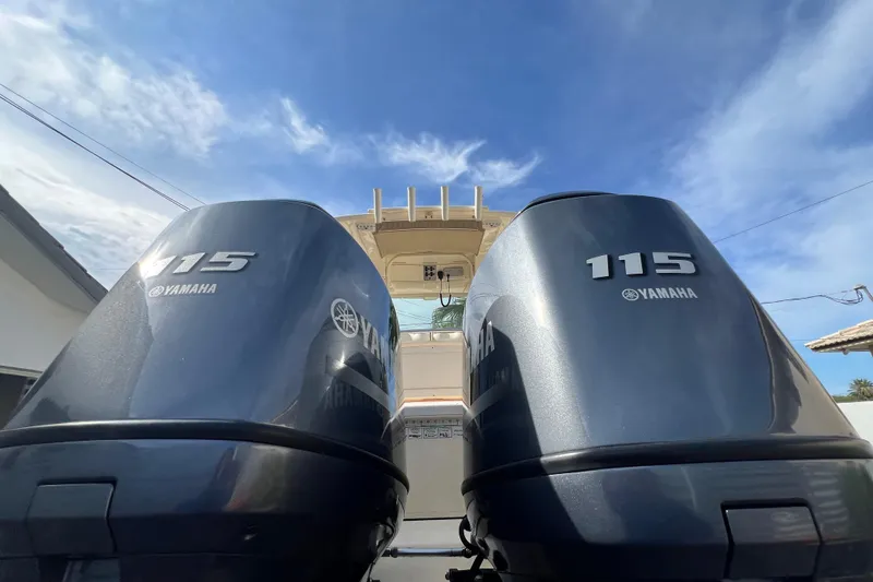 Slide: The Image of Twin Yamaha 115 engines on a 2014 Scout 245 XSF boat under a clear blue sky. - 33
