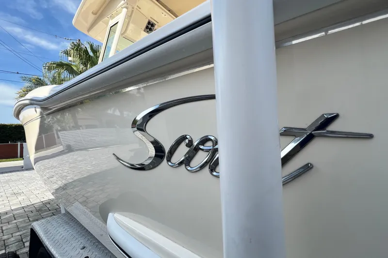 Slide: The Image of 2014 Scout 245 XSF boat with sleek design and chrome logo. - 89