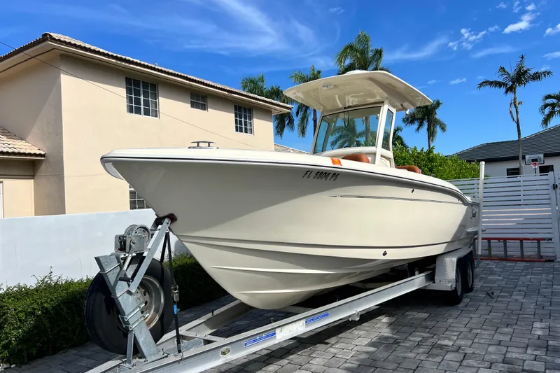 Slide: The Image of 2014 Scout 245 XSF boat on trailer, parked in residential driveway. - 24