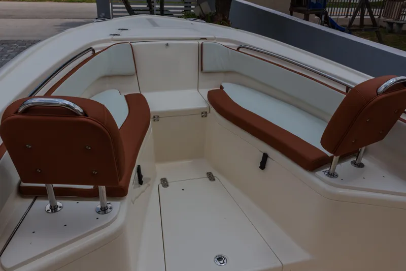 Slide: The Image of 2014 Scout 245 XSF boat interior with brown and white seating arrangement. - 5