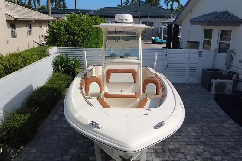 Slide: The Image of 2014 Scout 245 XSF boat with Garmin equipment, parked on a paved driveway. - 18